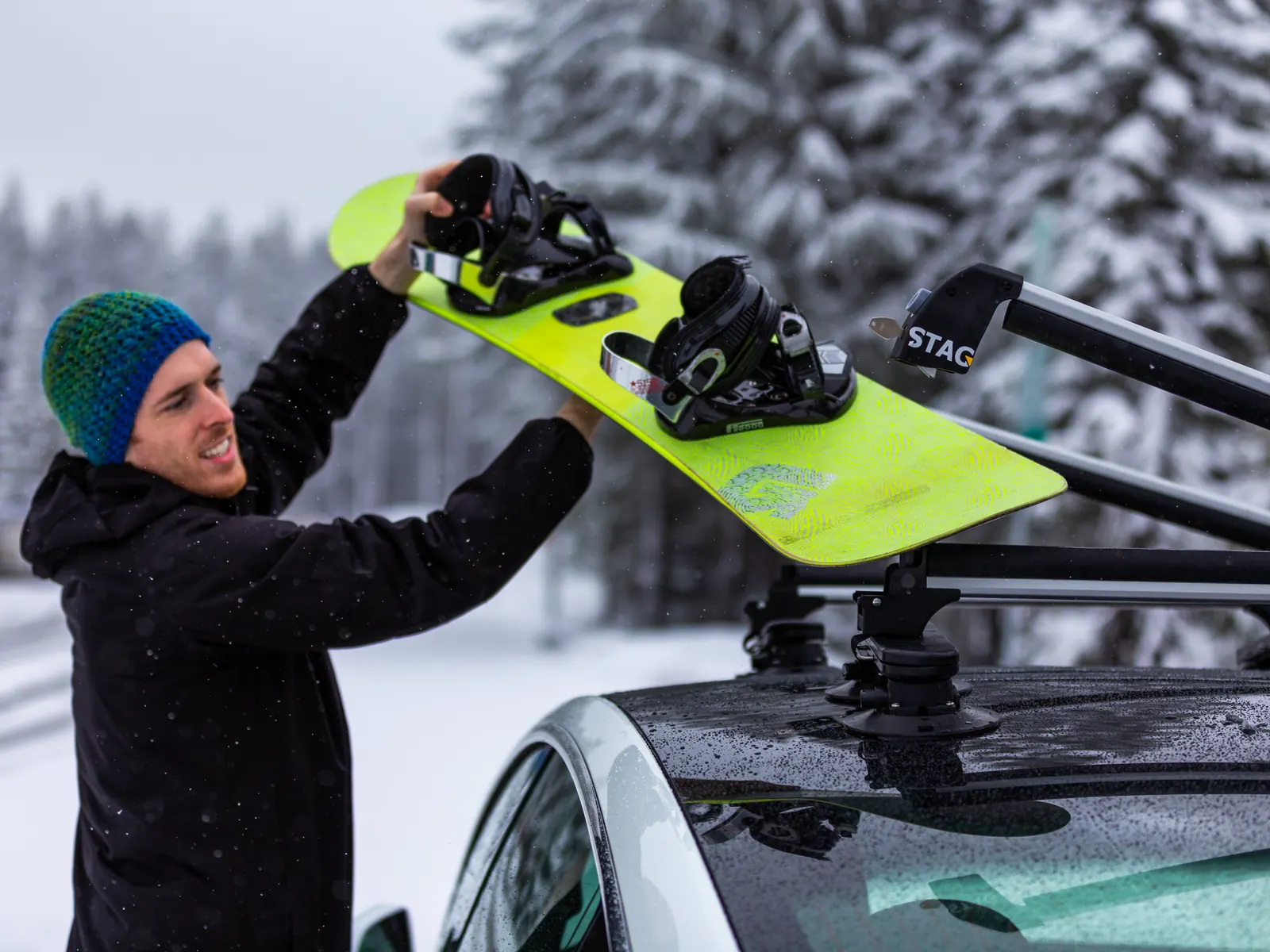 Loading a snowboard onto a STAG ski rack in the snow