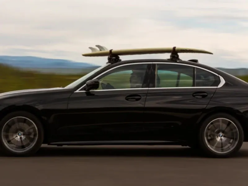 Surfboard on a STAG surf rack on a black sedan